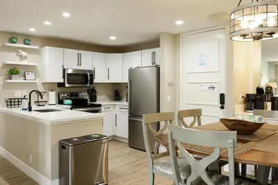 a kitchen with a table and a refrigerator at Oceanside Beach Condos in Oceanside