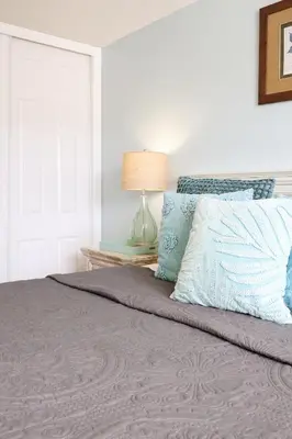 a bedroom with a bed with a lamp on a table at Oceanside Beach Condos in Oceanside