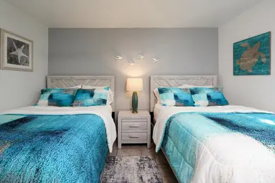 two beds sitting next to each other in a bedroom at Oceanside Beach Condos in Oceanside