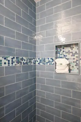a blue tiled bathroom with a mirror and towels at Oceanside Beach Condos in Oceanside