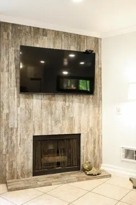 a living room with a fireplace with a flat screen tv above it at Oceanside Beach Condos in Oceanside