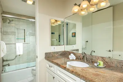 a bathroom with a sink and a large mirror at Oceanside Beach Condos in Oceanside