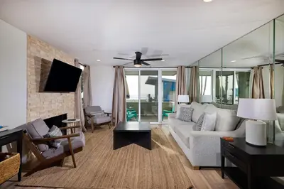 a living room with a couch and a ceiling fan at Oceanside Beach Condos in Oceanside