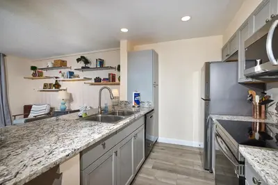 a kitchen with a sink and a refrigerator at Oceanside Beach Condos in Oceanside