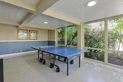 a blue ping pong table in a room with windows at Oceanside Beach Condos in Oceanside