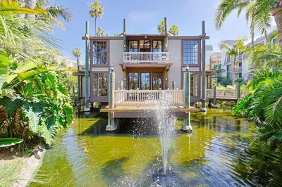 a house with a fountain in the middle of a pond at Oceanside Beach Condos in Oceanside