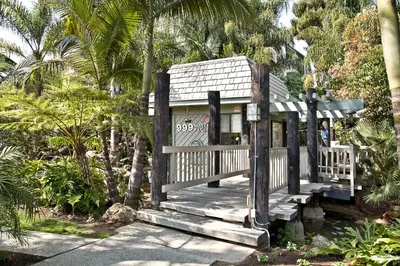 a small house with a porch and palm trees at Oceanside Beach Condos in Oceanside