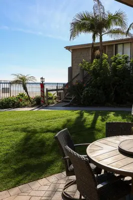a patio with a table and chairs in a yard at Oceanside Beach Condos in Oceanside