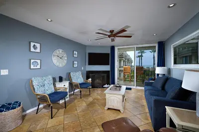 a living room with a couch and chairs and a clock at Oceanside Beach Condos in Oceanside