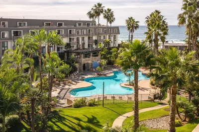 an aerial view of a resort with a pool and palm trees at Oceanside Beach Condos in Oceanside