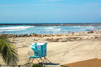 a beach with a blue lifeguard chair on the sand at Oceanside Beach Condos in Oceanside