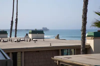 a dog sitting on top of a building near the ocean at Oceanside Beach Condos in Oceanside