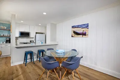 a kitchen and dining room with a glass table and chairs at Oceanside Beach Condos in Oceanside