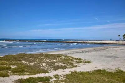 a beach with the ocean and a pier at Oceanside Beach Condos in Oceanside