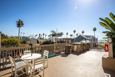 a patio with a table and chairs and a grill at Oceanside Beach Condos in Oceanside