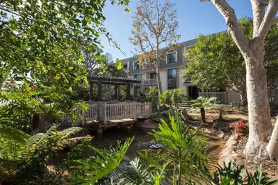 a garden with a bench in front of a building at Oceanside Beach Condos in Oceanside