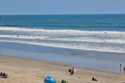 a group of people on a beach with the ocean at Oceanside Beach Condos in Oceanside