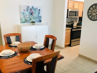 a dining room table with chairs and a kitchen at Oceanside Beach Condos in Oceanside