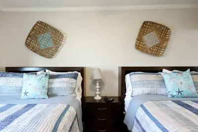 a bedroom with two beds and two mirrors on the wall at Oceanside Beach Condos in Oceanside