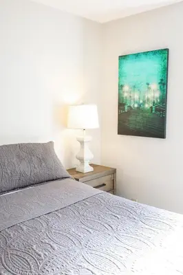 a bedroom with a bed and a lamp on a table at Oceanside Beach Condos in Oceanside