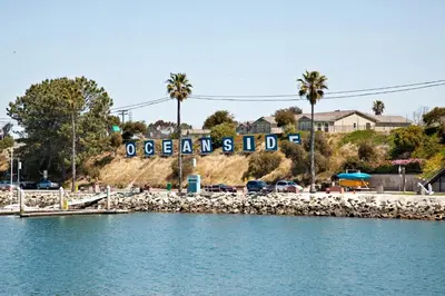 a sign on a hill next to a body of water at Oceanside Beach Condos in Oceanside
