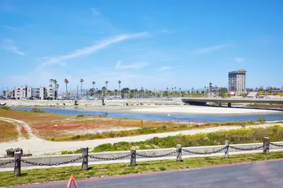 a view of a beach with palm trees and a bridge at Oceanside Beach Condos in Oceanside
