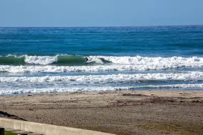 a person riding a wave on a surfboard in the ocean at Oceanside Beach Condos in Oceanside