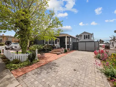 a home with a brick driveway in front of a house at Luxury beach home one block from ocean with spa, WiFi, & gorgeous outdoor space in San Diego