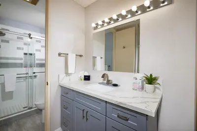 a bathroom with a sink and a mirror at Oceanside Beach Condos in Oceanside