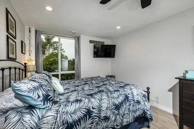 a bedroom with a bed with a blue and white comforter at Oceanside Beach Condos in Oceanside