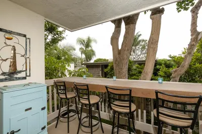 a bar on a screened porch with four stools at Oceanside Beach Condos in Oceanside