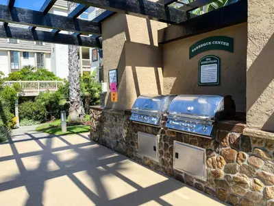 a building with a stone wall with a grill at Oceanside Beach Condos in Oceanside