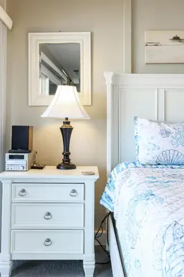 a bedroom with a bed and a lamp on a dresser at Oceanside Beach Condos in Oceanside