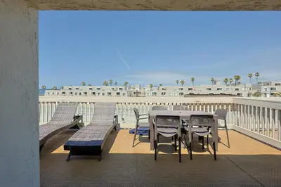 a table and chairs on a balcony with the beach at Oceanside Beach Condos in Oceanside