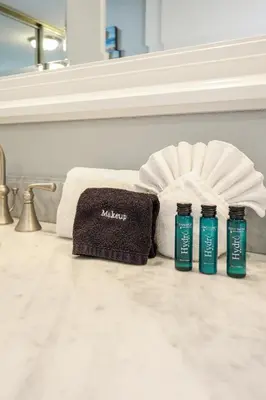 a bathroom with towels and two bottles of algal bleach at Oceanside Beach Condos in Oceanside