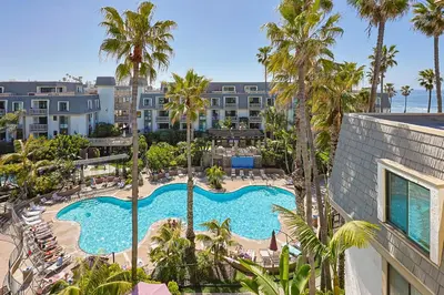 an aerial view of a resort swimming pool with palm trees at Oceanside Beach Condos in Oceanside