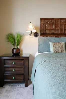 a bedroom with a bed and a nightstand with a plant on it at Oceanside Beach Condos in Oceanside