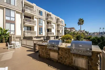 a patio with a grill and a building at Oceanside Beach Condos in Oceanside