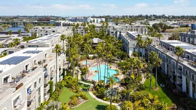 an aerial view of a resort with a pool and palm trees at Oceanside Beach Condos in Oceanside
