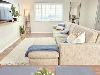 a living room with a couch with pillows on it at Historical Beach Bungalow Steps Away From Sand #5 in Newport Beach