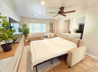 a living room with a bed and a couch at Historical Beach Bungalow Steps Away From Sand #5 in Newport Beach