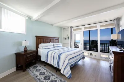 a bedroom with a bed with a view of the ocean at Beachfront Retreat in Oceanside