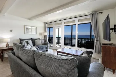 a living room with a couch and a view of the ocean at Beachfront Retreat in Oceanside