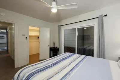 a bedroom with a bed and a ceiling fan at Beachfront Retreat in Oceanside