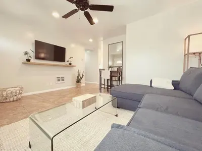 a living room with a blue couch and a ceiling fan at Beach Bungalow #3 in Newport Beach (A/C Included) in Newport Beach