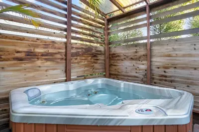 a jacuzzi tub in a room with a wooden wall at Cozy, home with hottub and patio in San Diego