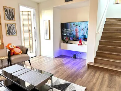 a living room with a tv and a stair case at Comfort Retreat 3B3B Villa in Quail Hill Irvine in Irvine