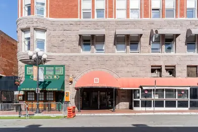 a brick building with a red awning on a street at The Keating in San Diego