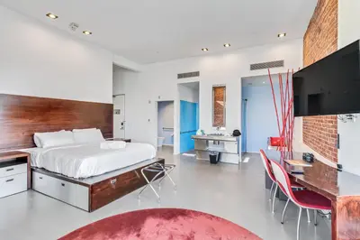 a bedroom with a bed and a desk and a television at The Keating in San Diego