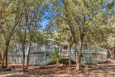 a house with a large deck in the woods at The Bungalow Partial Home Rental in Julian